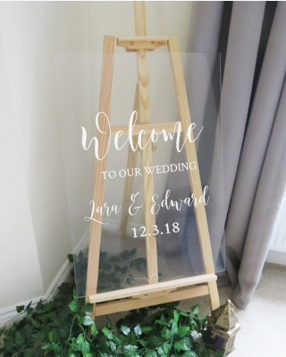 Welcome wedding sign made from a glass board with text saying welcome to our wedding Lara & Edward 12.3.18