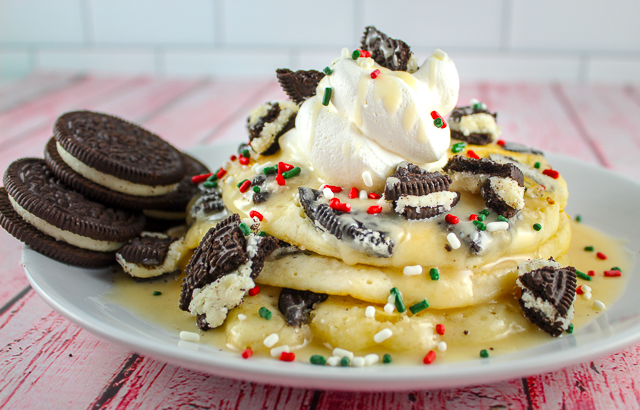 Copycat IHOP Oreo Pancakes top with powdered sugar glaze, whipped cream and sprinkles