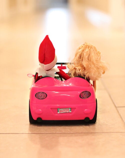 elf on the self is riding a ferrari with barbie to a date