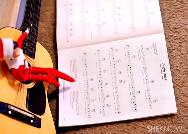 elf on the shelf playing with his guitar and singing