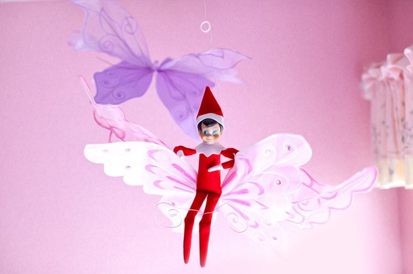elf on the shelf riding a beautiful and colorful butterfly 