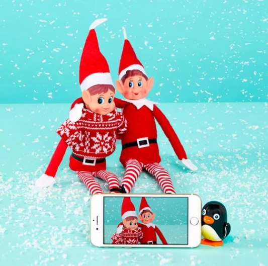 2 adorable elf on the shelf taking selfies in the snow