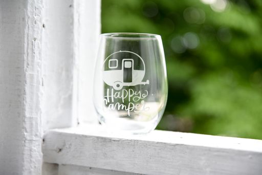 Etched wine glass with a camper van and a text saying Happy camper design on it