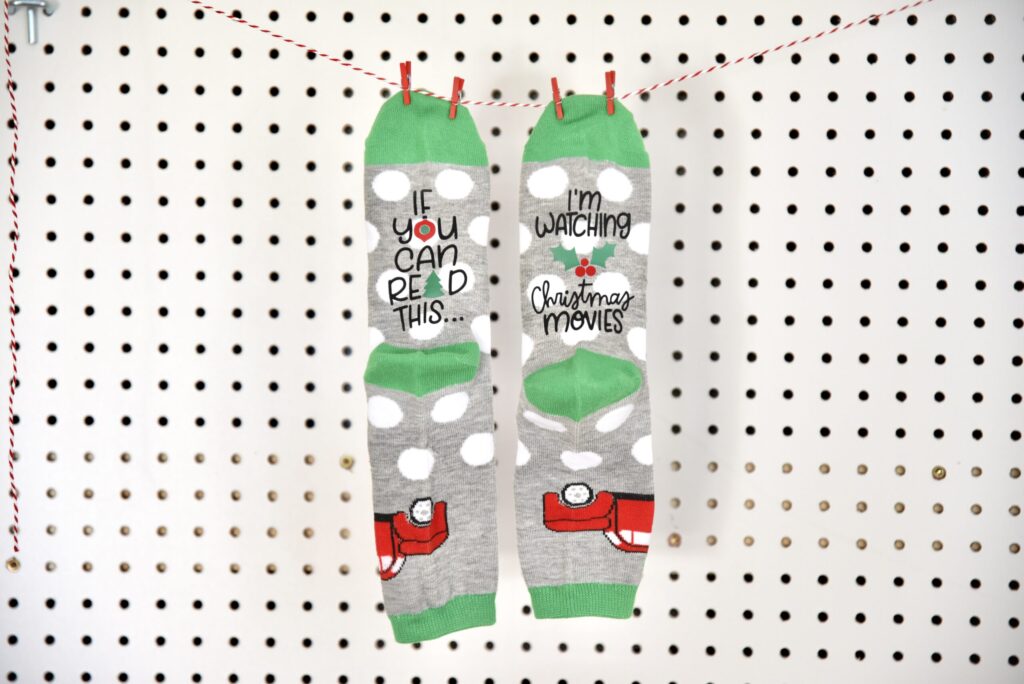 A pair of Holiday socks with text saying If You Can Read This and I'm watching Christmas Movies