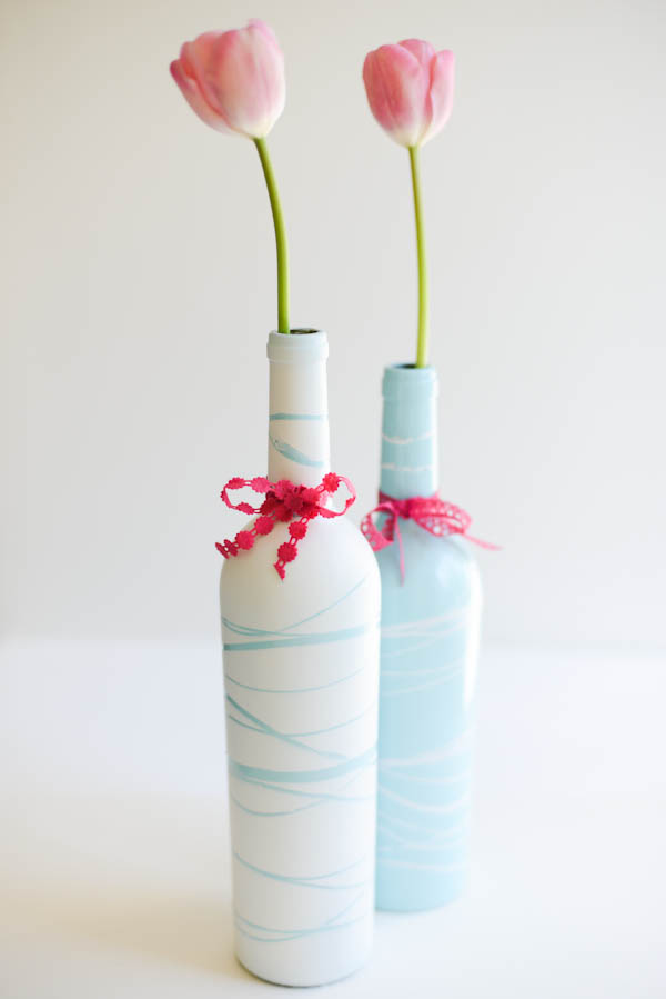 Beautiful pastel wine bottles with a stem of pink rose on each bottle