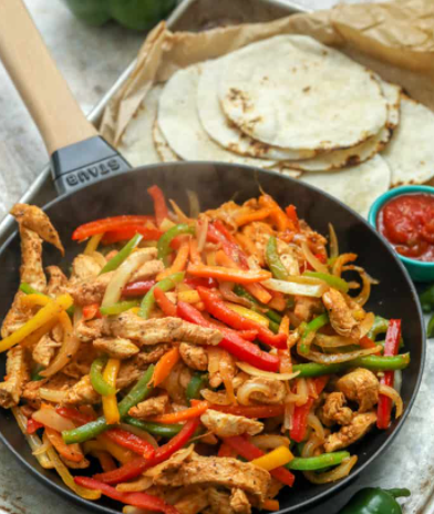 Easy Tender Juicy Chicken Fajitas Recipe with cheese, sour cream, lettuce, guacamole, and Pico de Gallo