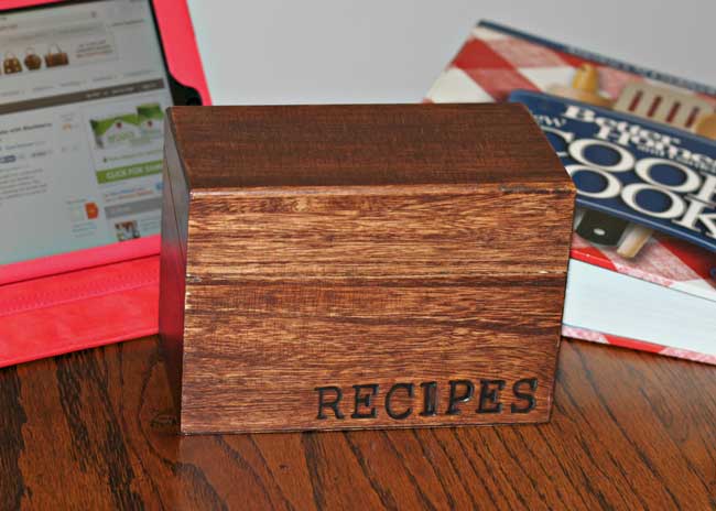 wooden recipe box with wood-burned text on it says Recipes