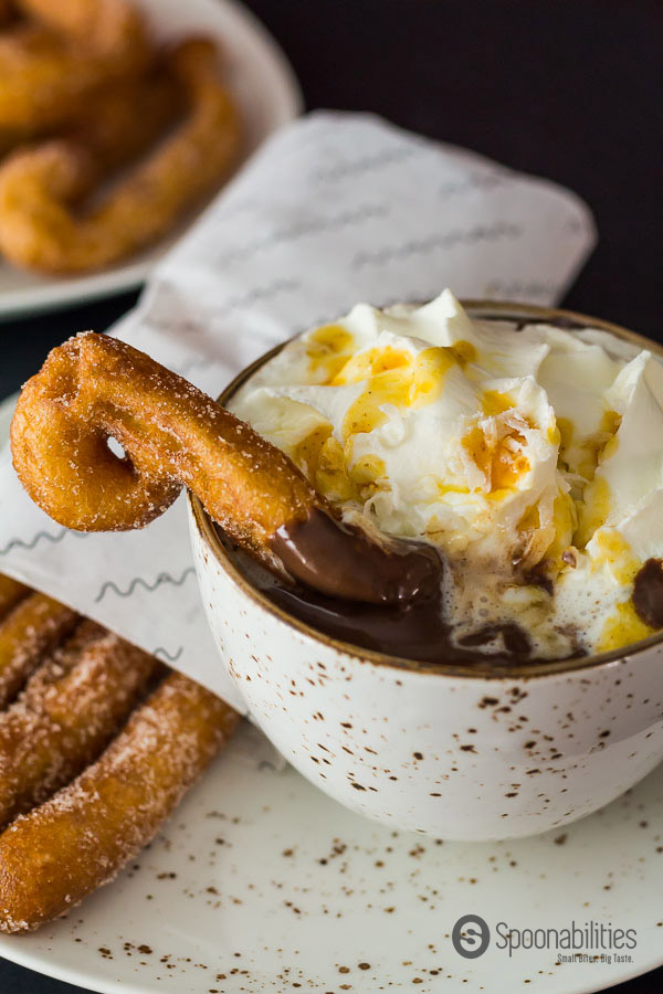 Spiced Spanish Hot Chocolate topped with whipped cream and drizzled with some Cinnamon Maple Syrup