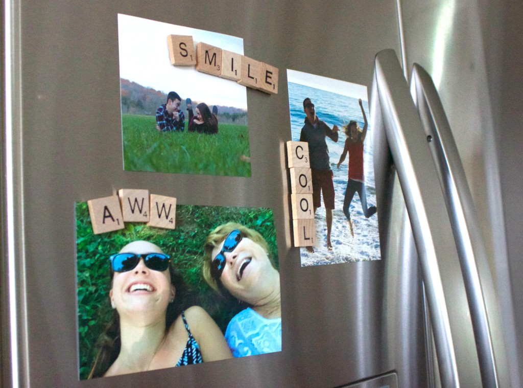 Scrabble tile magnets on top of some photos on the fridge
