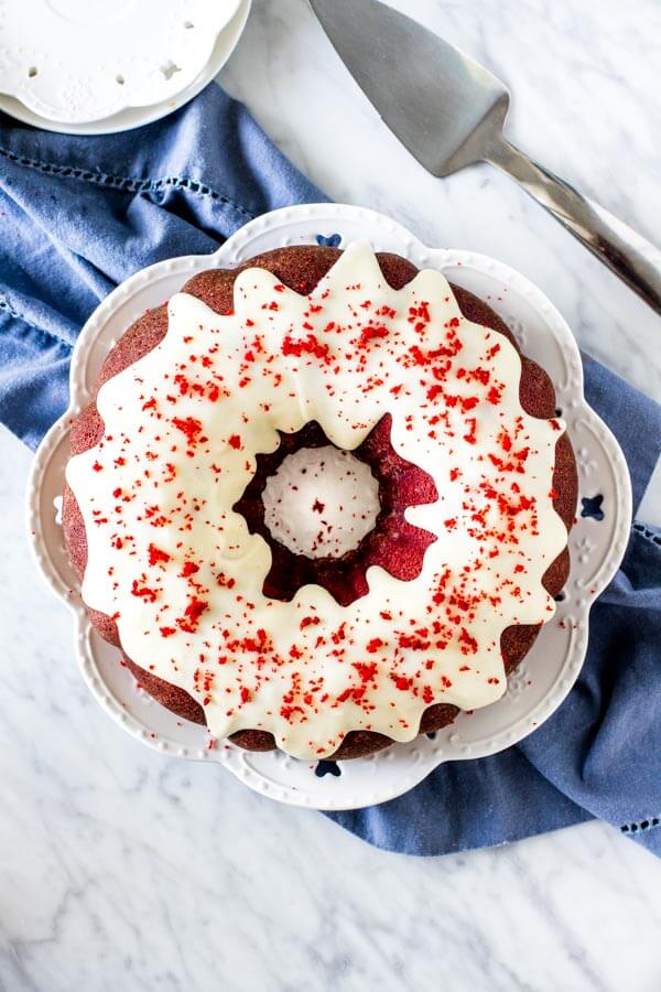 RED VELVET BUNDT CAKE topped with cream cheese glaze with a hint of cocoa powder