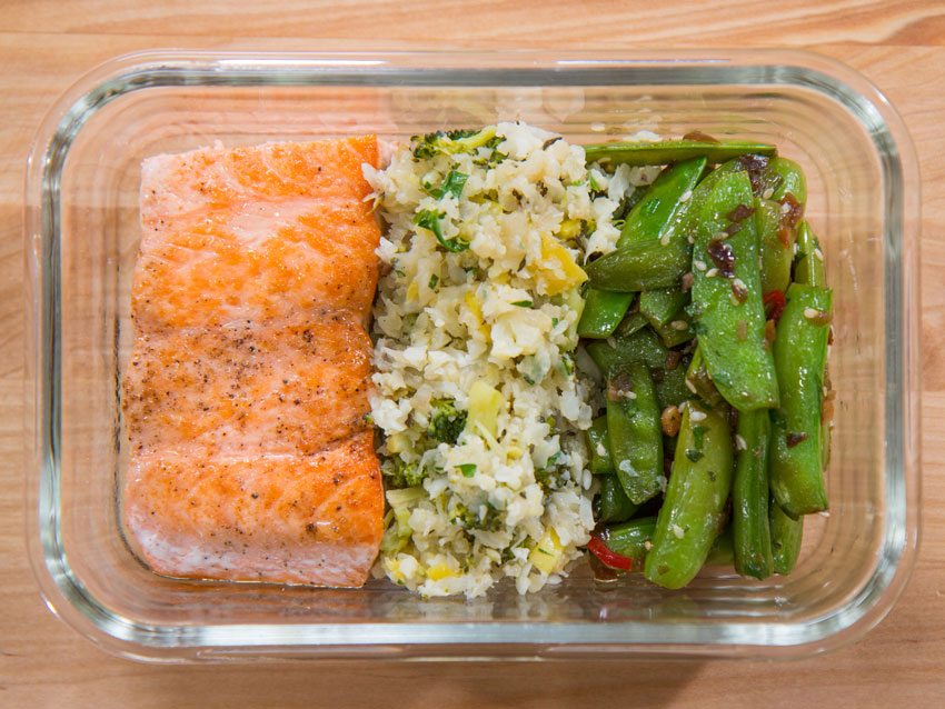 Crispy salmon filets served with low carb cauliflower rice and blistered snap peas meal prep
