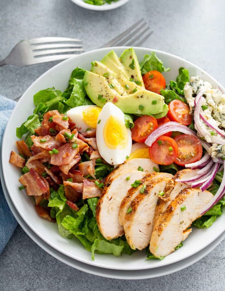 Cobb Salad loaded with chicken, crispy bacon, hard boiled eggs, tomatoes, avocado, blue cheese and dressing
