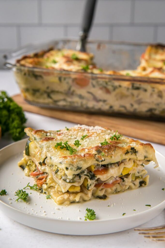 Garden Vegetable Lasagna is made of up layers of plenty of sautéed vegetables cheeses and creamy spinach sauce.