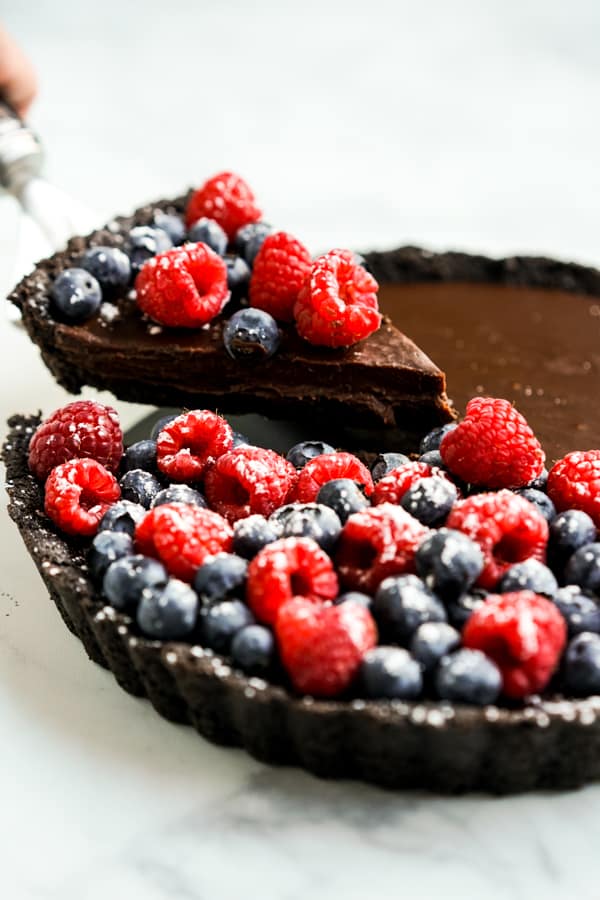 No-Bake Chocolate Tart top with berries and sprinkle berries with powdered sugar