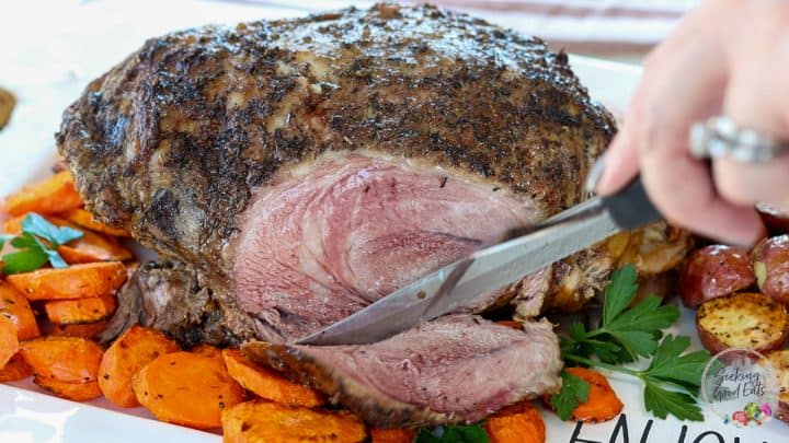 slow cooker leg of lamb on top of the vegetables and herbs perfect for Holidays dinner.