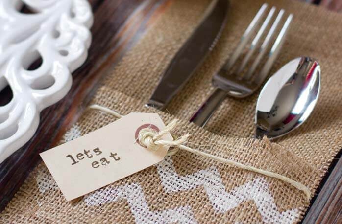 Burlap utensil holders that has a tag on it that says lets eat