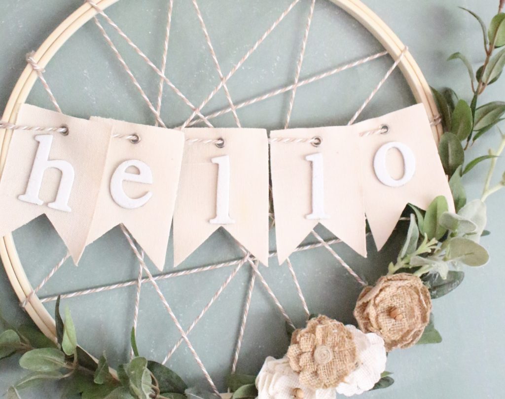 Farmhouse embroidery hoop wreath that has banner in the middle saying hello
