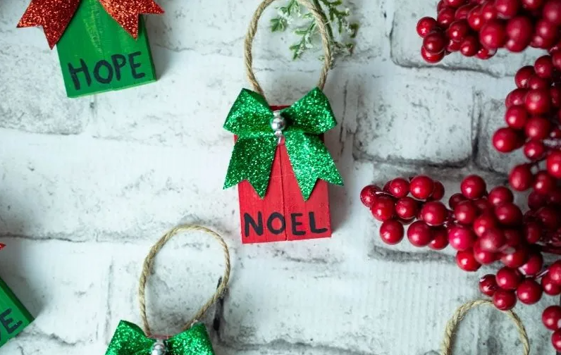 Easy to make Dollar Tree Tumbling Tower Christmas Ornaments has a text on them saying Hope and Noel