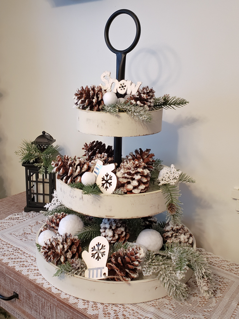 Winter tiered tray filled with snowy pine cones